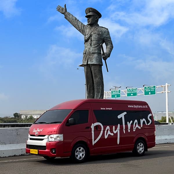 Shuttle Daytrans di depan patung